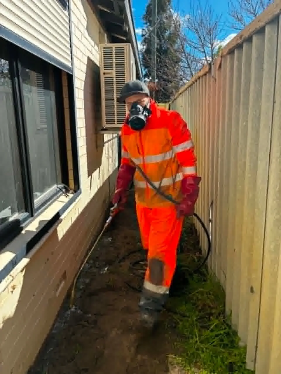 FAB technician applying targeted exterior pest treatment along a Perth home perimeter.