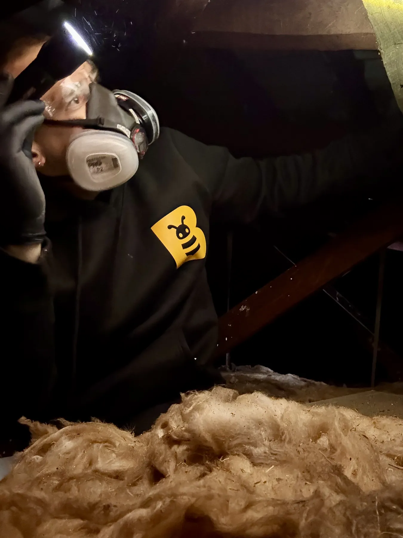 FAB Pest Control technician in a respirator inspecting a Perth roof void with disturbed insulation.