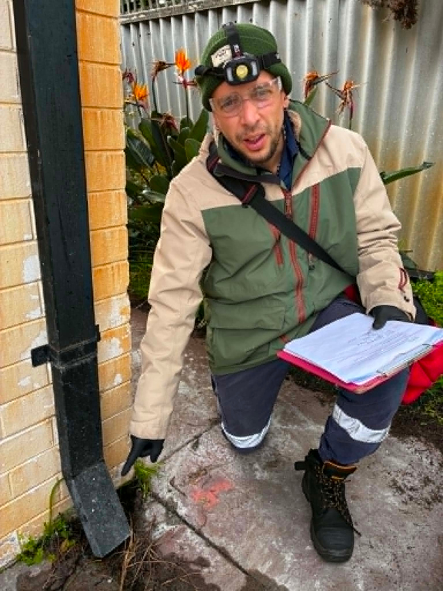 Fabien inspecting paving beside a wall where the slab edge is obscured
