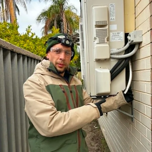 Fabien checking an external wall and air-conditioning penetration for termite risk conditions