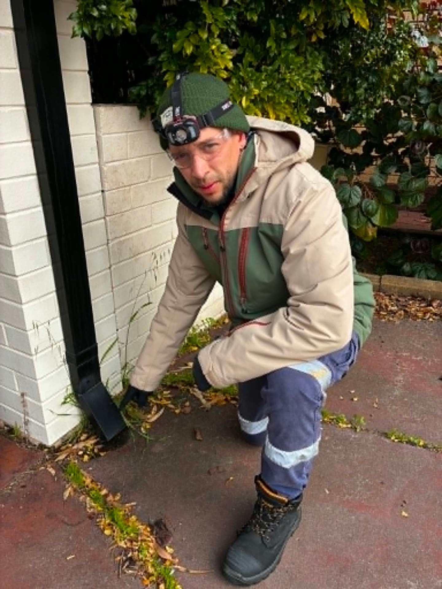 Fabien inspecting a raised garden bed beside an external wall